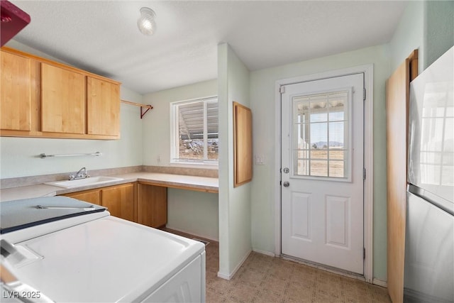 kitchen featuring light countertops, separate washer and dryer, plenty of natural light, and a sink