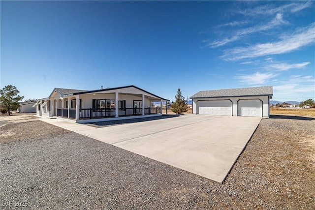 manufactured / mobile home with a garage, an outbuilding, and covered porch