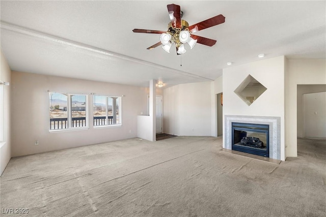 unfurnished living room featuring ceiling fan, carpet, and a glass covered fireplace