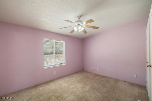 carpeted empty room with ceiling fan and a textured ceiling