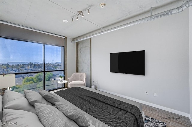 bedroom with baseboards and wood finished floors