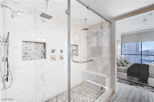 ensuite bathroom with a stall shower, ensuite bath, and wood finished floors