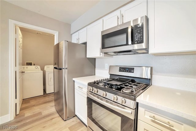 kitchen with white cabinetry, light wood-style flooring, independent washer and dryer, and stainless steel appliances