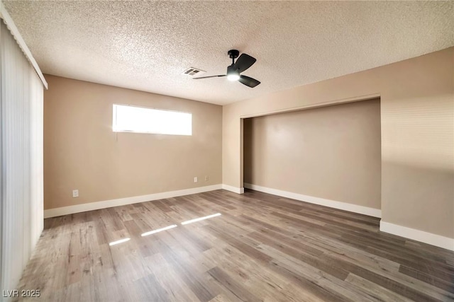 unfurnished bedroom featuring wood finished floors, a closet, and baseboards