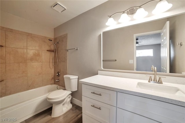 bathroom featuring visible vents, toilet, wood finished floors, vanity, and  shower combination