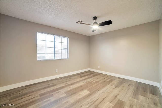 unfurnished room featuring visible vents, a textured ceiling, wood finished floors, baseboards, and ceiling fan