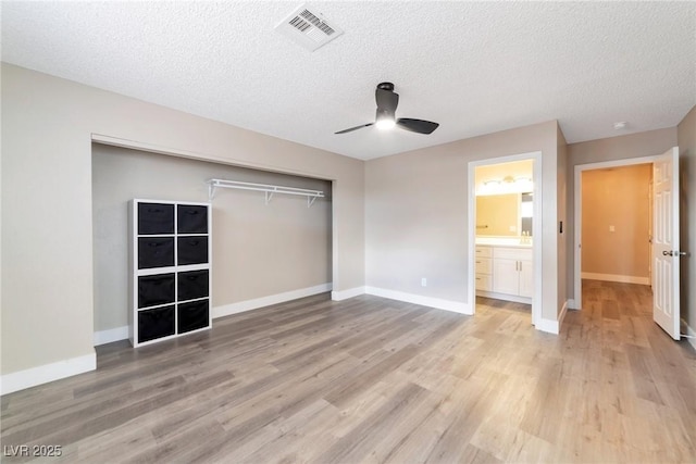 unfurnished bedroom with a closet, visible vents, baseboards, and light wood-style floors