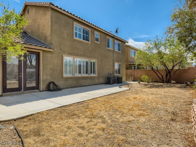 back of property featuring stucco siding, fence, cooling unit, and a patio