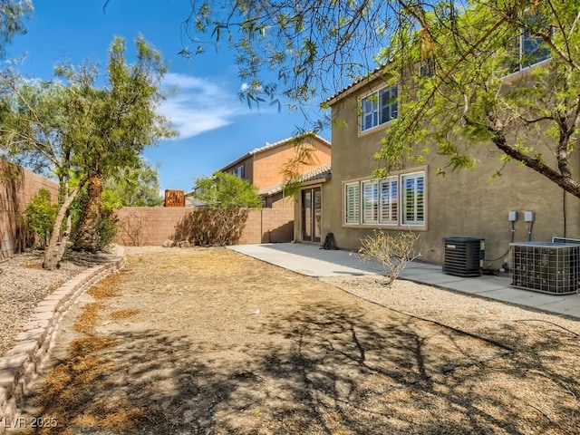 rear view of property with stucco siding, a patio, a fenced backyard, and central air condition unit