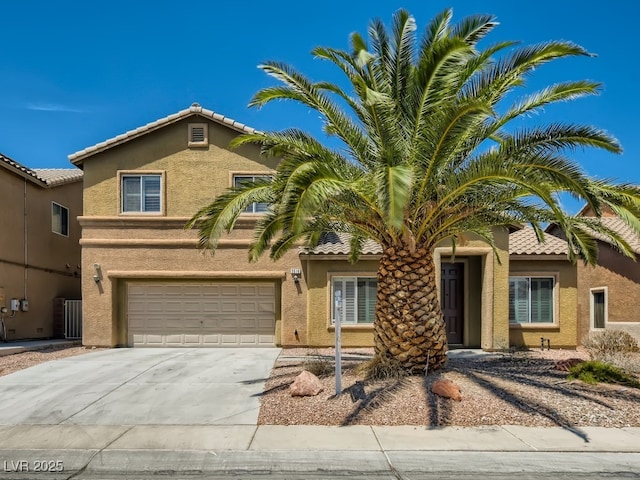 view of front of house featuring concrete driveway, a tile roof, an attached garage, and stucco siding