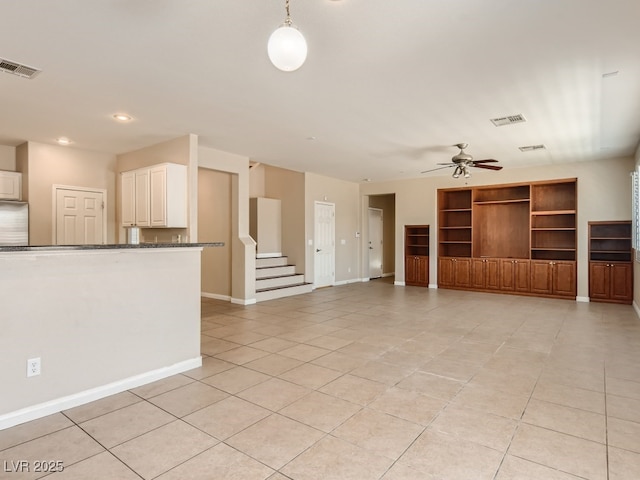 unfurnished living room featuring baseboards, visible vents, a ceiling fan, and light tile patterned flooring