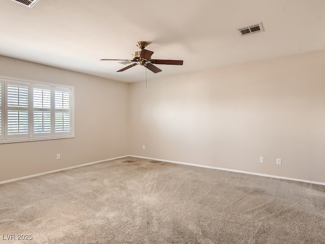 carpeted spare room featuring ceiling fan, visible vents, and baseboards