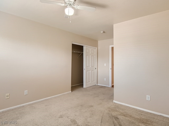 unfurnished bedroom featuring a ceiling fan, a closet, light carpet, and baseboards