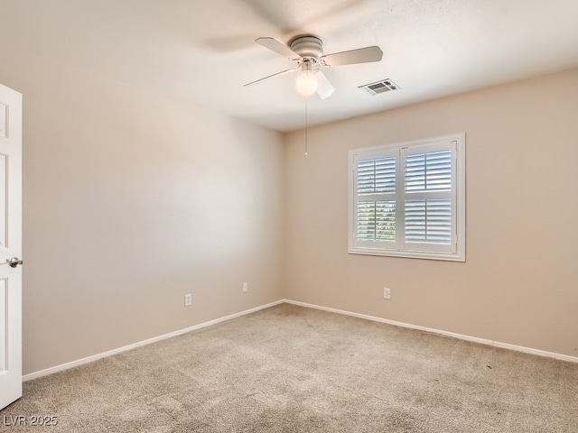 carpeted spare room featuring baseboards, visible vents, and a ceiling fan