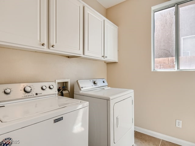 laundry room with cabinet space, light tile patterned floors, baseboards, and washer and dryer