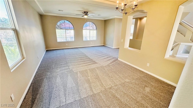 spare room featuring ceiling fan with notable chandelier, carpet floors, and baseboards