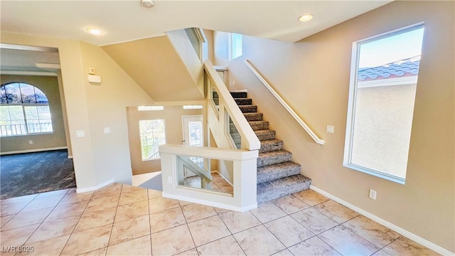 stairs featuring vaulted ceiling, baseboards, tile patterned flooring, and recessed lighting