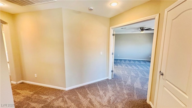 corridor with carpet floors, baseboards, and visible vents