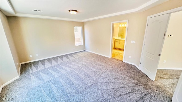 spare room featuring light carpet, visible vents, and baseboards