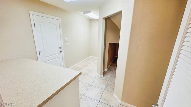 hallway with light tile patterned flooring and baseboards