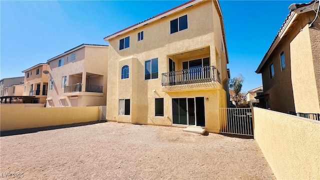 back of house featuring fence and stucco siding