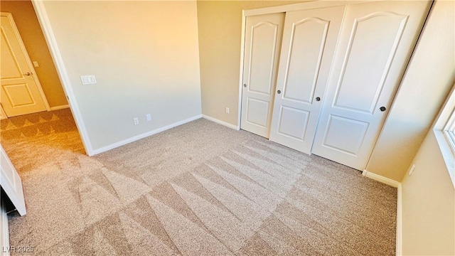 unfurnished bedroom featuring a closet, carpet flooring, and baseboards