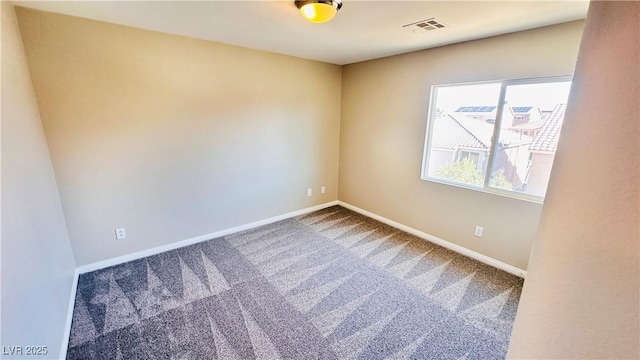 spare room with carpet floors, baseboards, and visible vents