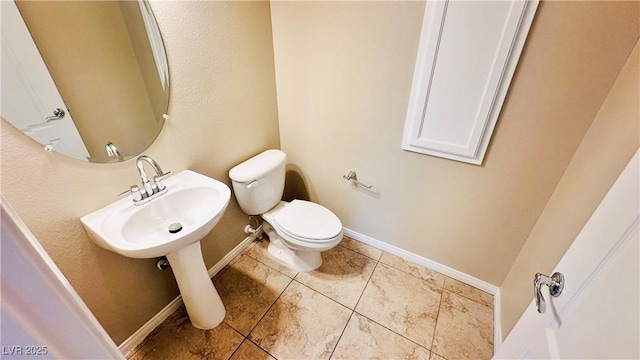 bathroom with toilet, tile patterned flooring, and baseboards