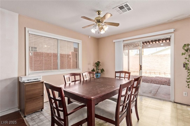 dining area with ceiling fan, light floors, and visible vents