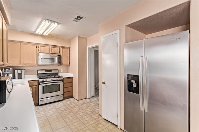 kitchen with light floors, visible vents, light countertops, appliances with stainless steel finishes, and light brown cabinetry