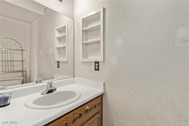 bathroom featuring vanity and a textured wall