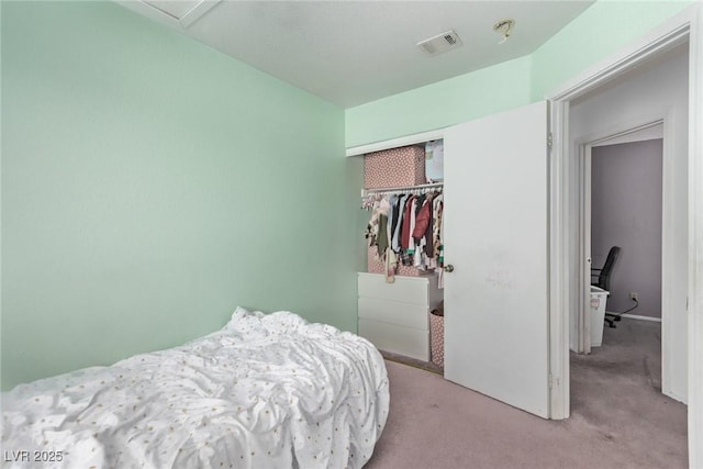 carpeted bedroom featuring a closet and visible vents