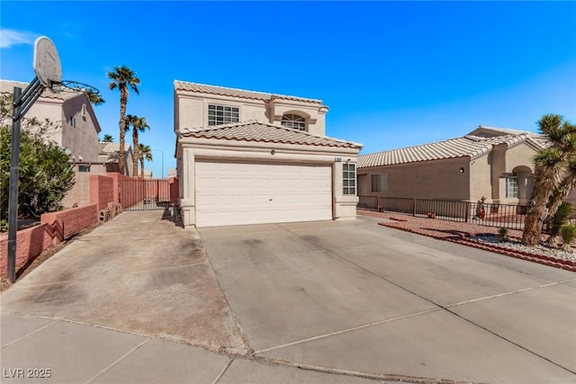 mediterranean / spanish-style house featuring a garage, fence, concrete driveway, and stucco siding