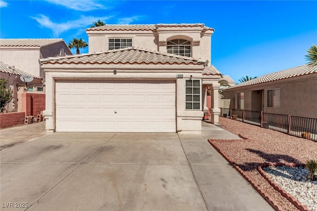 mediterranean / spanish-style house featuring a garage, fence, a tiled roof, concrete driveway, and stucco siding