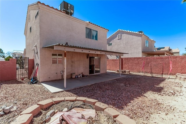 back of property featuring stucco siding, a patio area, fence, and central air condition unit