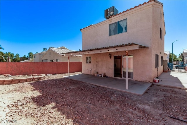 rear view of property featuring cooling unit, a patio area, a fenced backyard, and stucco siding