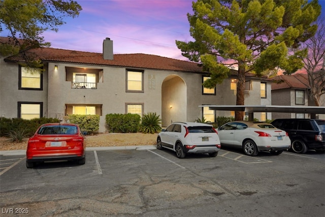 exterior space featuring uncovered parking and a chimney