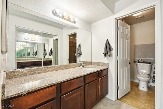 bathroom featuring toilet, tile patterned flooring, visible vents, and vanity