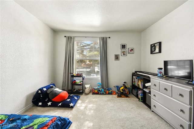 playroom featuring carpet and a textured ceiling