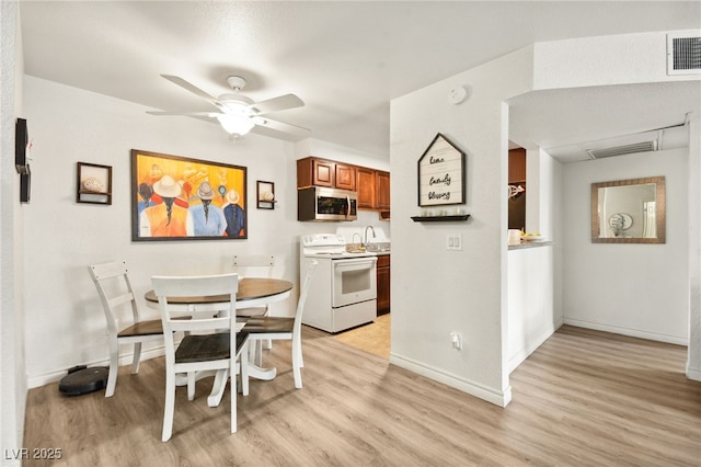 dining area featuring light wood finished floors, visible vents, and a ceiling fan