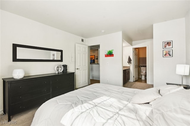 bedroom with light carpet, ensuite bath, and visible vents