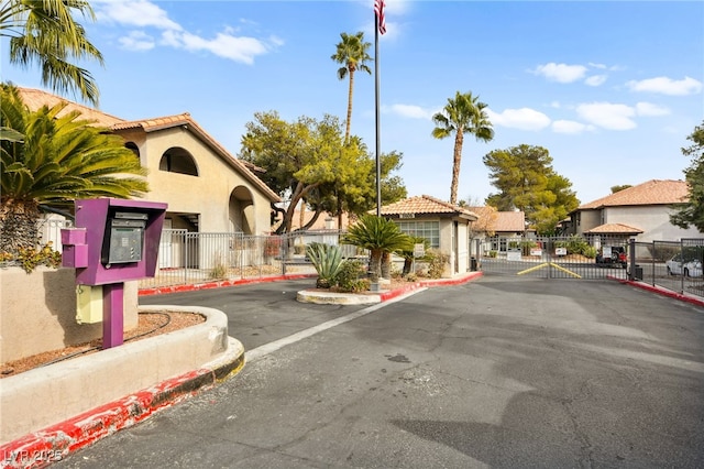 view of road featuring a gate, a gated entry, and curbs