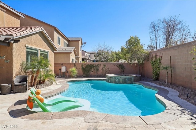 view of swimming pool featuring a fenced backyard, a pool with connected hot tub, and a patio