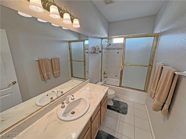 bathroom featuring enclosed tub / shower combo, toilet, visible vents, vanity, and tile patterned floors