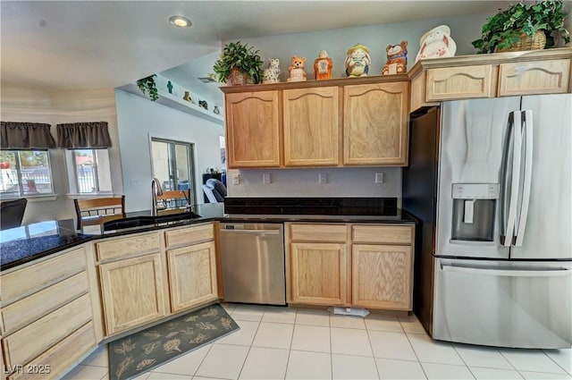 kitchen with light tile patterned floors, appliances with stainless steel finishes, a sink, and light brown cabinets