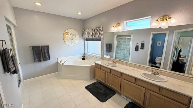 bathroom featuring toilet, tile patterned floors, a sink, a garden tub, and a wealth of natural light