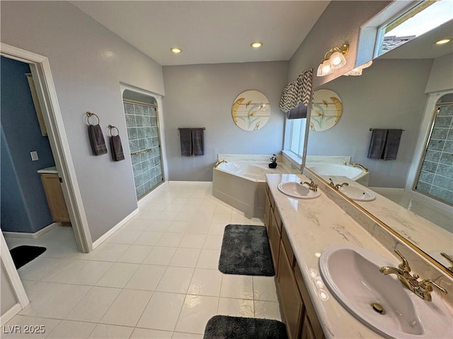 bathroom with double vanity, baseboards, a bath, tile patterned floors, and a sink