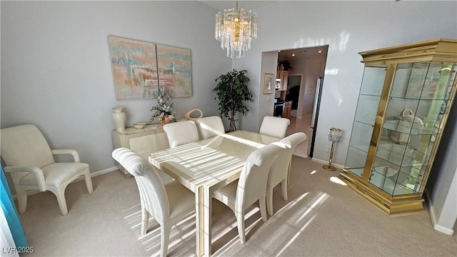 dining space with baseboards, a notable chandelier, and light colored carpet