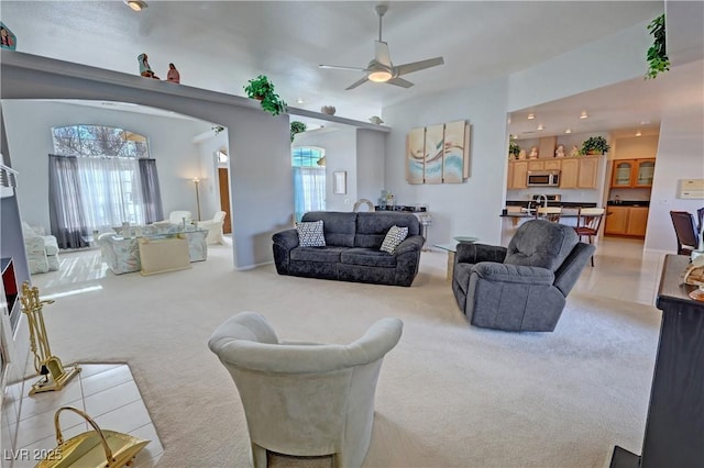 living area featuring light carpet and a ceiling fan