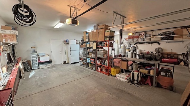 garage with a garage door opener and freestanding refrigerator